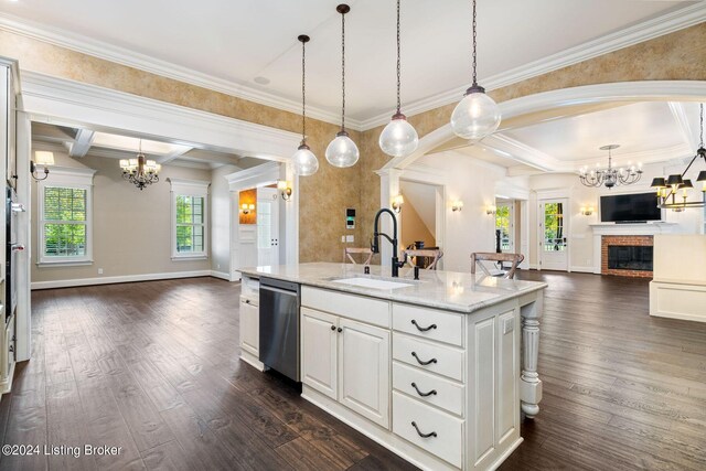 kitchen featuring dishwasher, a center island with sink, sink, a fireplace, and white cabinetry