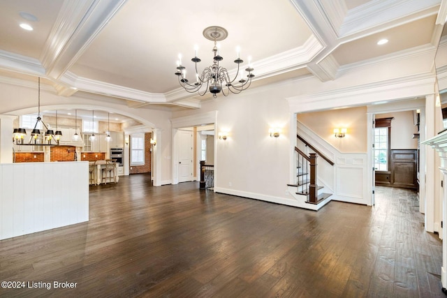 unfurnished living room with dark wood-type flooring, coffered ceiling, an inviting chandelier, beamed ceiling, and ornamental molding