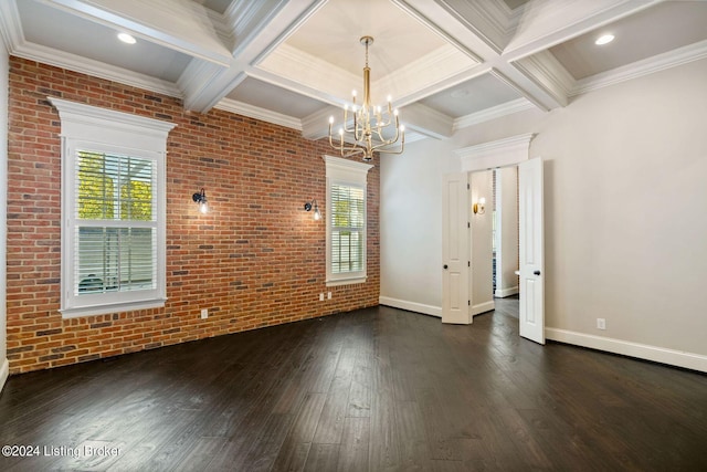 spare room featuring dark wood-type flooring, coffered ceiling, beamed ceiling, brick wall, and a chandelier