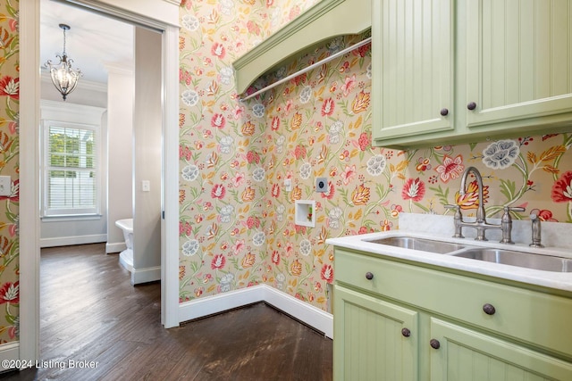 kitchen featuring dark hardwood / wood-style flooring, ornamental molding, sink, a chandelier, and green cabinets