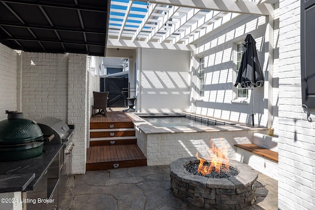 view of patio with a wooden deck and an outdoor fire pit