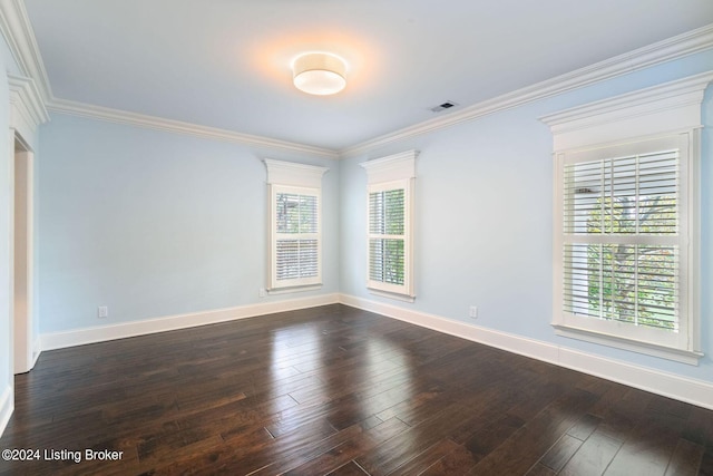 empty room featuring plenty of natural light, dark hardwood / wood-style flooring, and ornamental molding