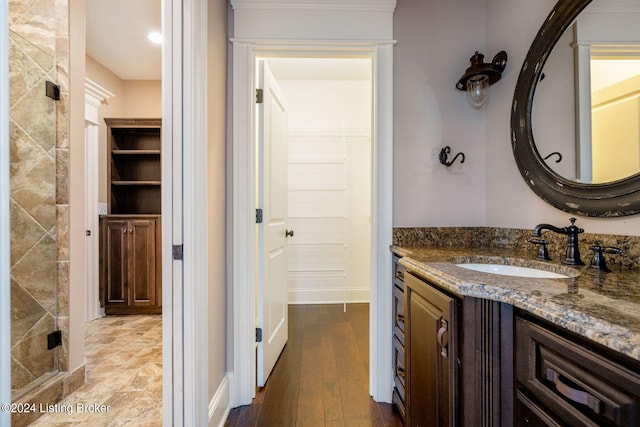 bathroom featuring hardwood / wood-style floors, vanity, and a shower with door