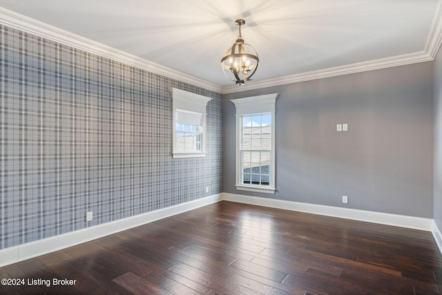 spare room with ornamental molding, dark hardwood / wood-style floors, and a notable chandelier