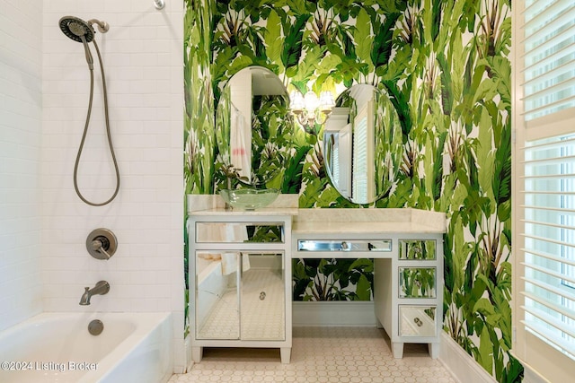 bathroom with a healthy amount of sunlight, sink, and tiled shower / bath