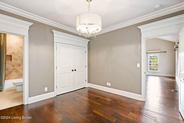 interior space featuring dark hardwood / wood-style flooring, ornamental molding, and an inviting chandelier