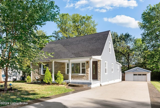 view of front of home featuring covered porch, a garage, an outbuilding, and a front yard