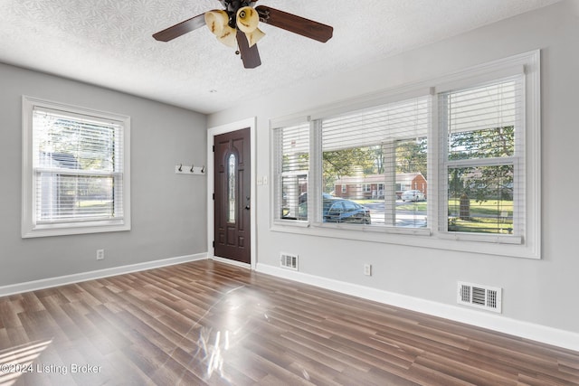 entryway with ceiling fan, dark hardwood / wood-style flooring, and a textured ceiling