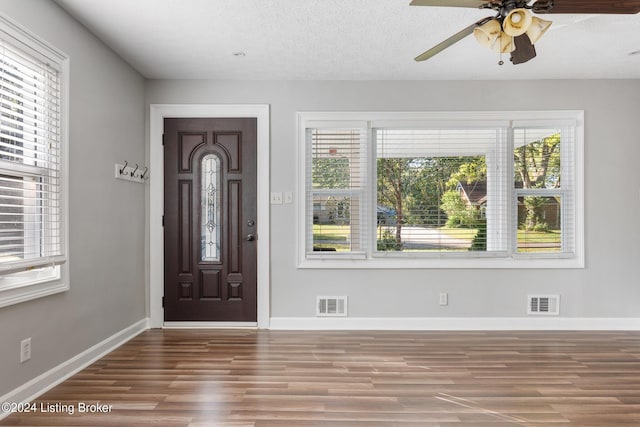 foyer entrance with a textured ceiling, hardwood / wood-style flooring, and ceiling fan