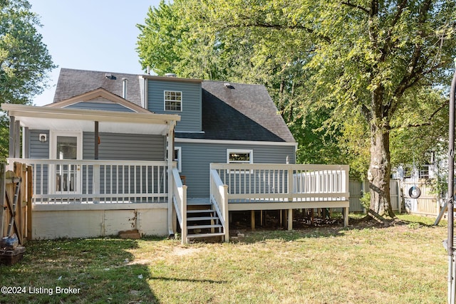 rear view of property with a deck and a lawn