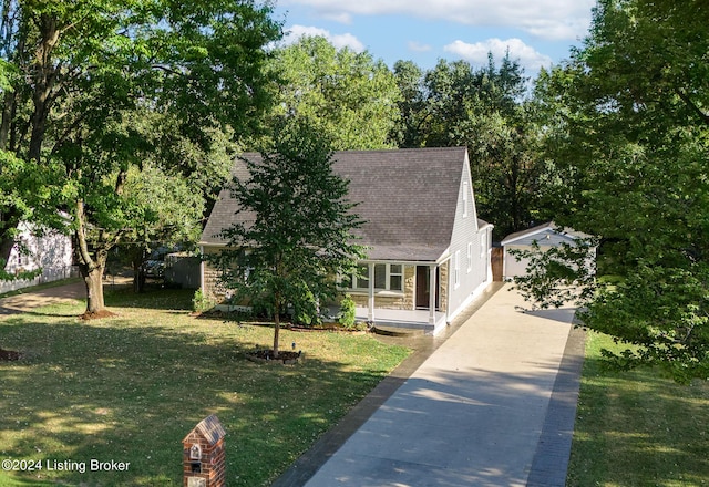 view of front of home with a porch, a garage, an outdoor structure, and a front lawn