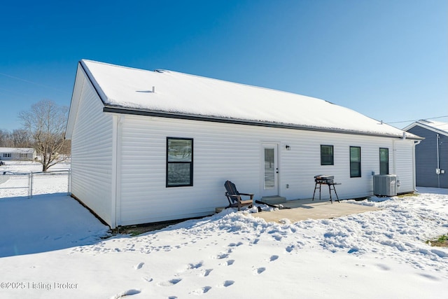 snow covered property with central air condition unit