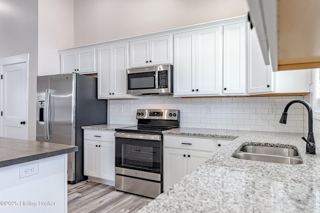 kitchen with appliances with stainless steel finishes, white cabinetry, and sink