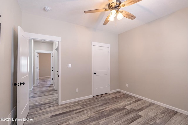 unfurnished bedroom with a closet, ceiling fan, and wood-type flooring