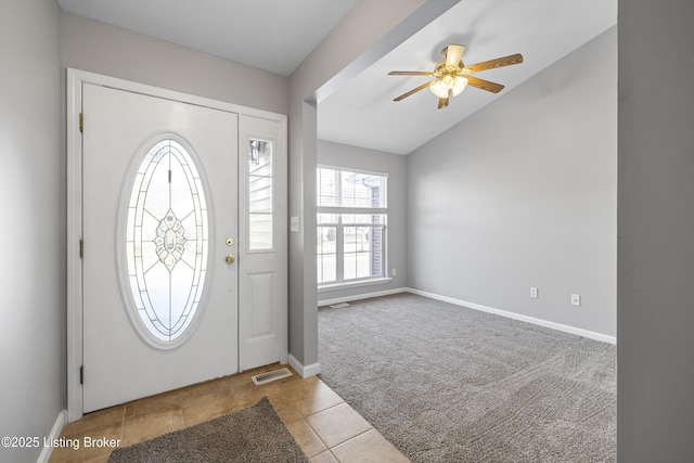 carpeted entrance foyer featuring ceiling fan and vaulted ceiling