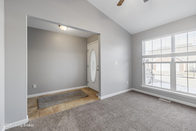 foyer with vaulted ceiling, light colored carpet, and ceiling fan