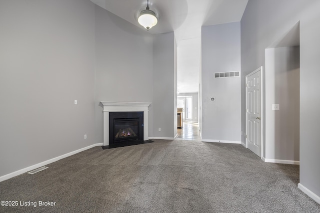 unfurnished living room featuring a high ceiling and carpet