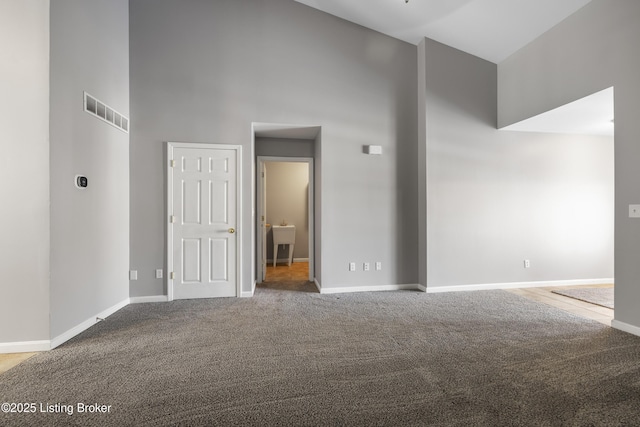 unfurnished room featuring high vaulted ceiling and carpet flooring