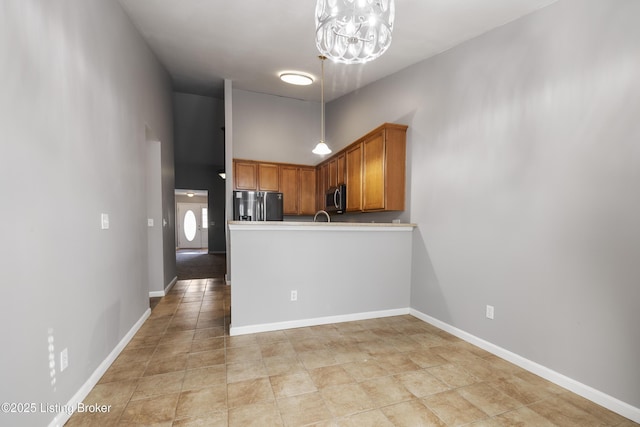 kitchen with an inviting chandelier, stainless steel appliances, and a high ceiling