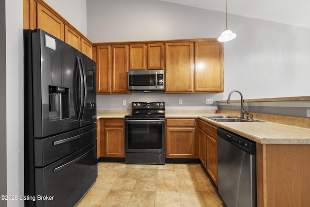 kitchen featuring vaulted ceiling, appliances with stainless steel finishes, sink, and hanging light fixtures