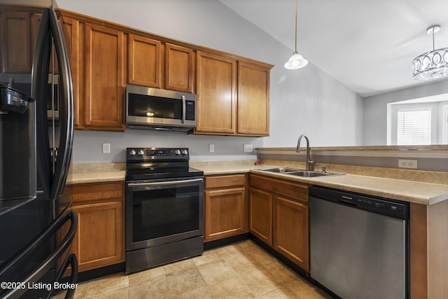 kitchen with pendant lighting, lofted ceiling, appliances with stainless steel finishes, and sink