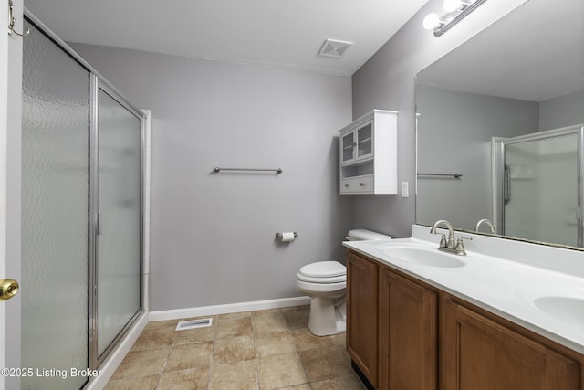 bathroom featuring vanity, toilet, and an enclosed shower