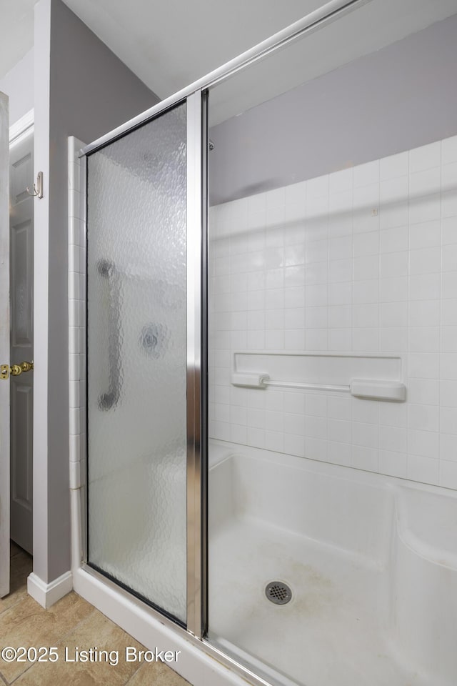 bathroom with tile patterned flooring and a shower with shower door