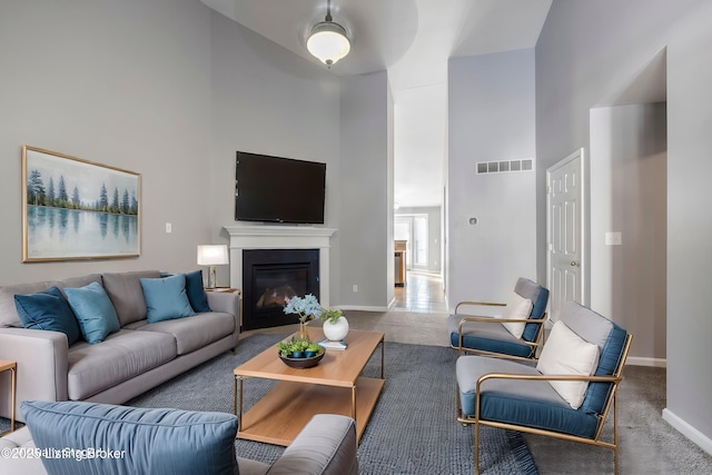 living room featuring carpet floors and a high ceiling