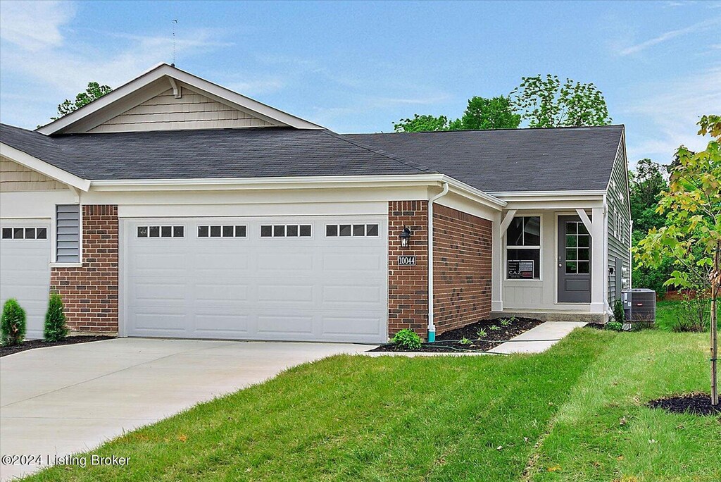 single story home featuring a garage, a front lawn, and central air condition unit