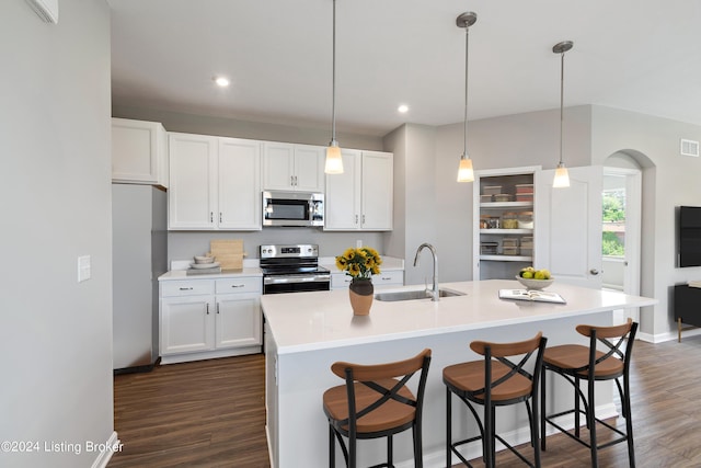 kitchen featuring white cabinetry, sink, stainless steel appliances, and a center island with sink