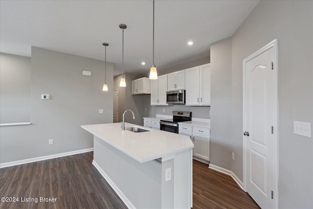 kitchen featuring sink, hanging light fixtures, dark wood-type flooring, stainless steel appliances, and a center island with sink