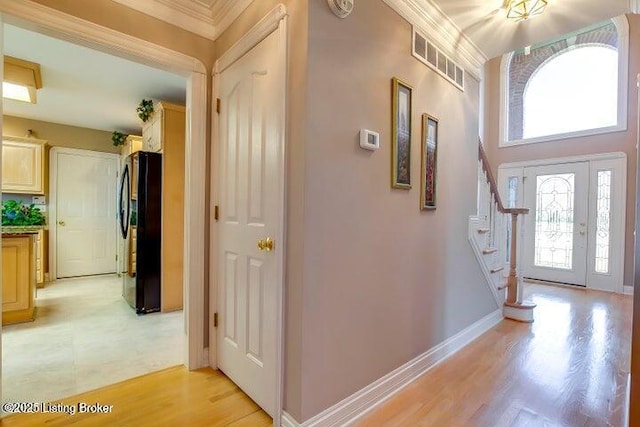 entrance foyer featuring light wood-type flooring and crown molding