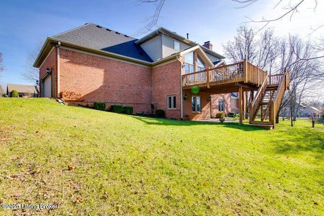 rear view of house with a wooden deck, a yard, and a garage