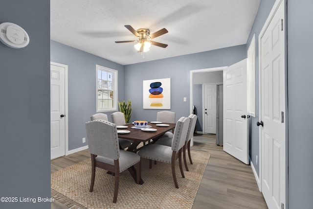 dining area featuring a textured ceiling, hardwood / wood-style flooring, and ceiling fan