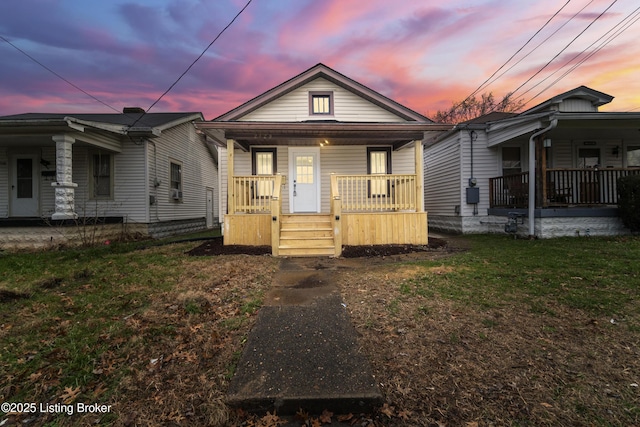 bungalow-style home with a yard and covered porch