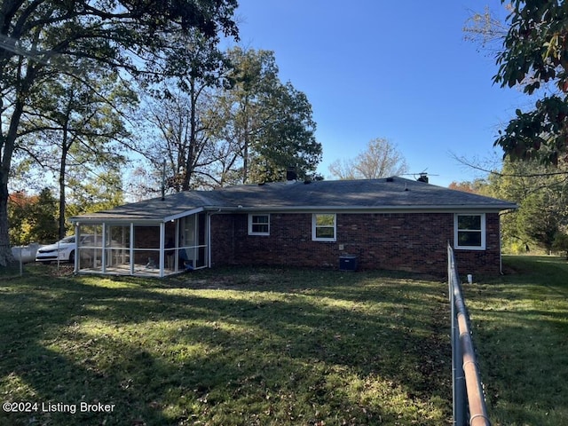 back of property with a sunroom and a yard