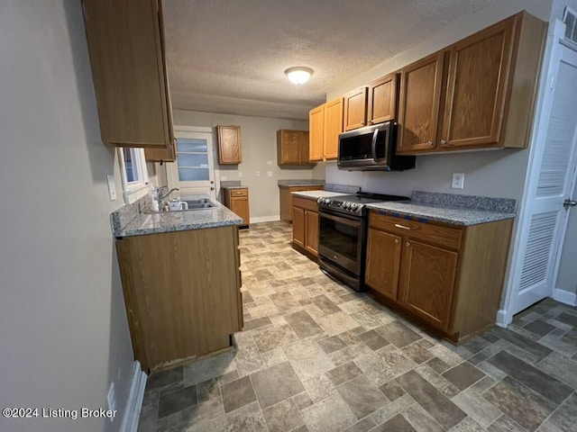 kitchen with a textured ceiling, black / electric stove, and sink