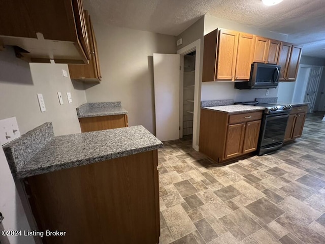 kitchen with black appliances and a textured ceiling