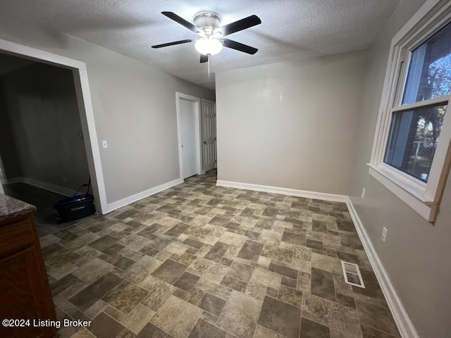 unfurnished bedroom featuring ceiling fan and a textured ceiling