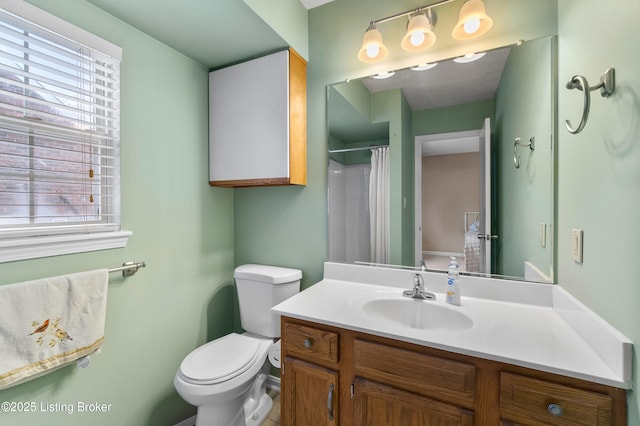 bathroom featuring toilet, a shower with shower curtain, and vanity