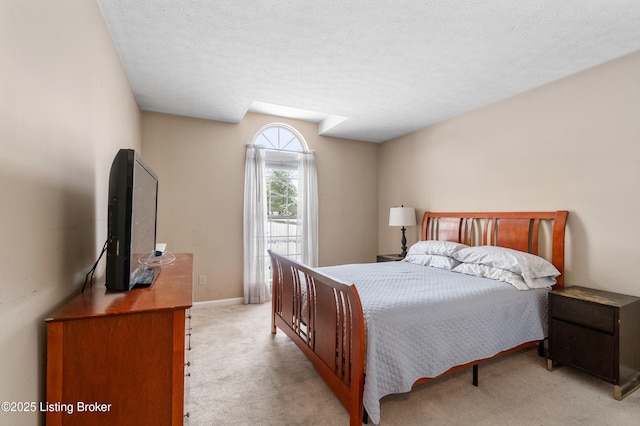 bedroom featuring a textured ceiling and light carpet