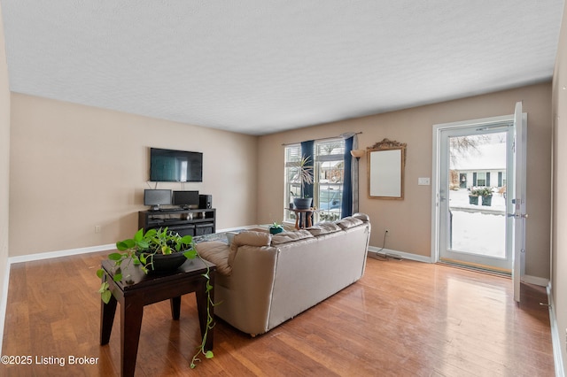 living room featuring light wood-type flooring and a textured ceiling