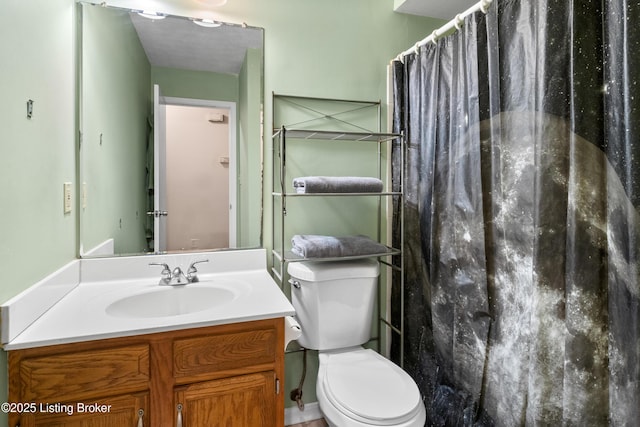 bathroom featuring toilet, walk in shower, and vanity