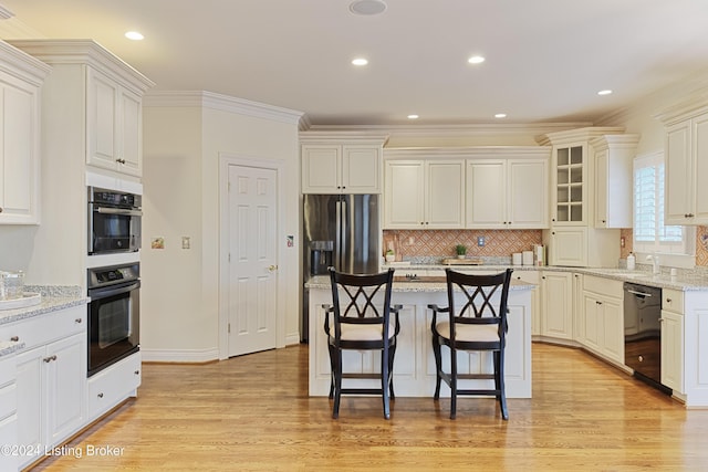 kitchen with a center island, black dishwasher, light wood-type flooring, stainless steel fridge with ice dispenser, and light stone countertops