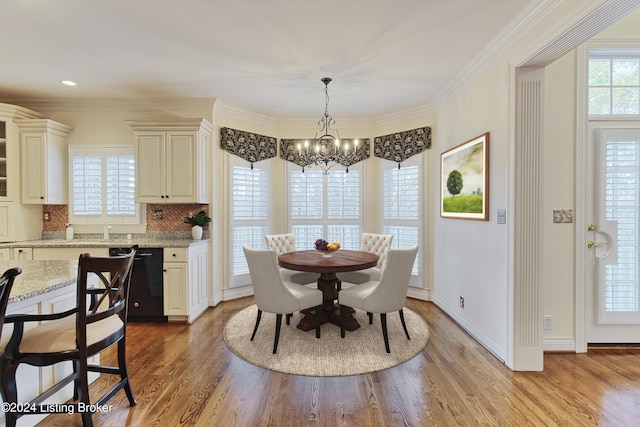 dining area featuring crown molding, light hardwood / wood-style flooring, and a chandelier