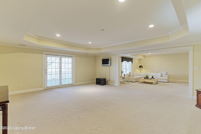 unfurnished living room featuring a tray ceiling, crown molding, and light colored carpet