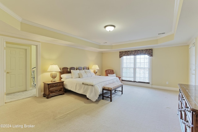 bedroom with light colored carpet, a raised ceiling, and ornamental molding