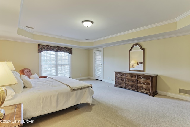 bedroom featuring a tray ceiling, crown molding, and light carpet