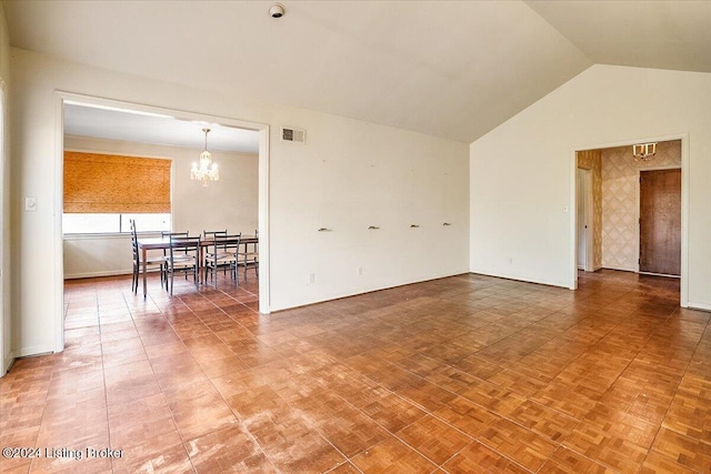 spare room featuring parquet flooring, an inviting chandelier, and vaulted ceiling