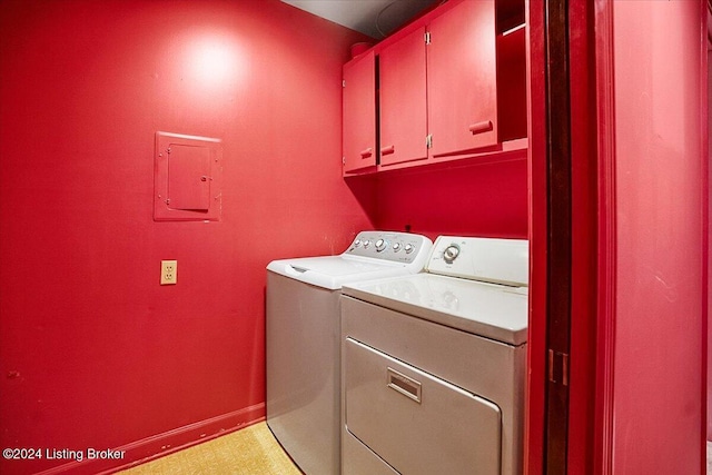 clothes washing area featuring cabinets, washing machine and dryer, and electric panel